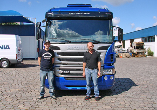 Tomé Tonet (D) com o filho Felipe, em março de 2013, quando foi adquirido o caminhão Scania envolvido no acidente. - Brasdiesel/Divulgação